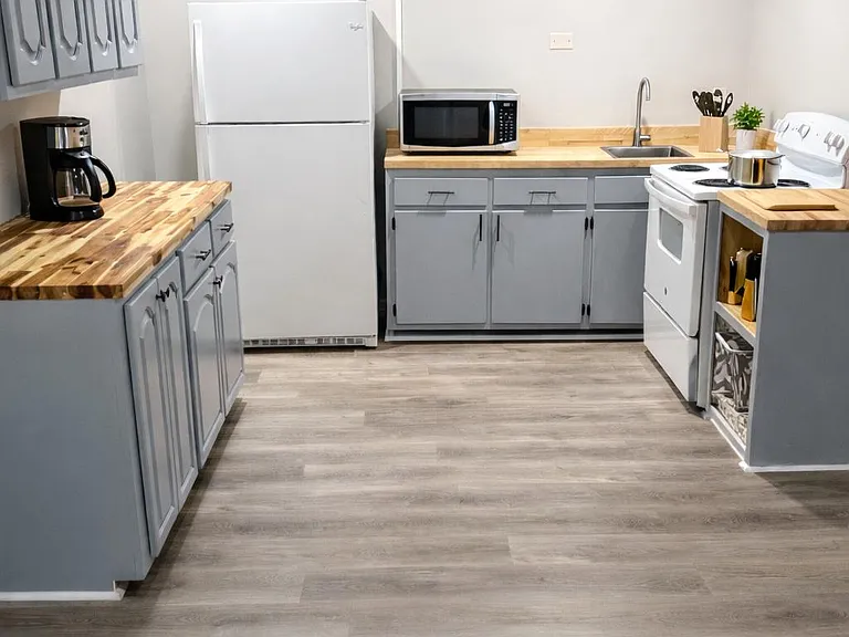 Kitchen stocked with basic pots, pans, microwave, coffemaker, cutlery and plates.