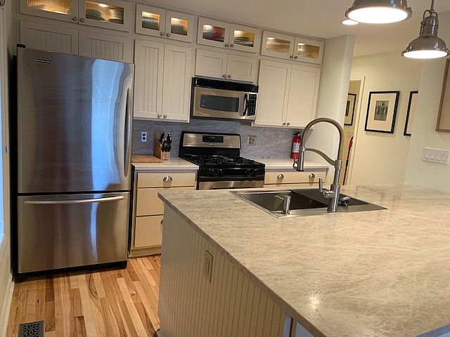Stone countertops & backsplash with stainless appliances.