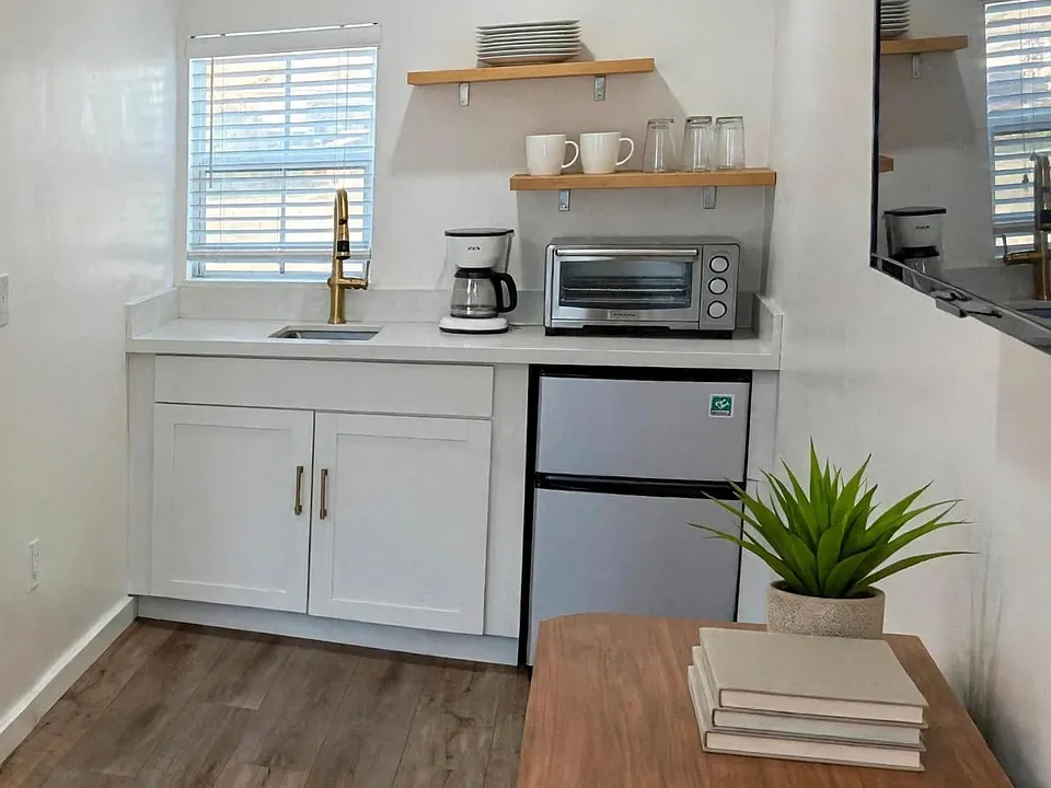 Compact kitchen area with floating shelves. (Furnished for display)
