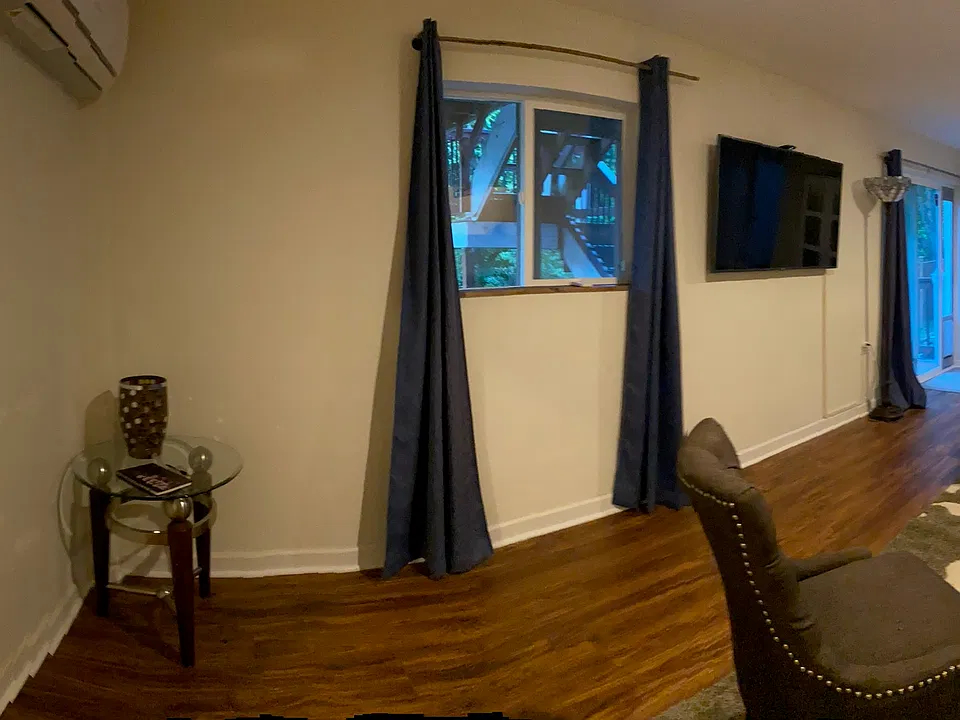 Living room with view of lobby/front entrance, 58" smart TV and french doors leading to back paver patio and yard