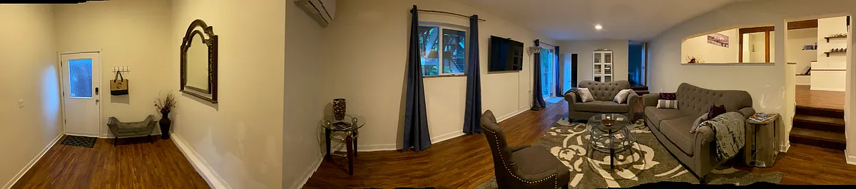 Living room with view of lobby/front entrance, 58" smart TV and french doors leading to back paver patio and yard - 7766 SW Bayberry Dr