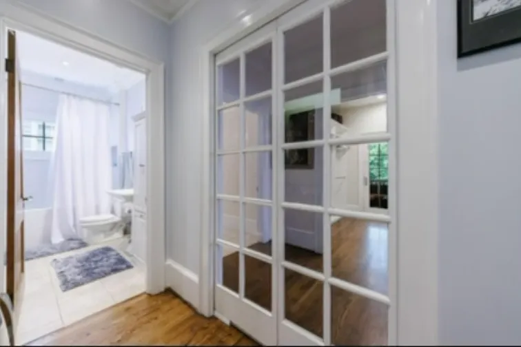 Sliding french doors separates living areas - front of the house includes secondary bathroom/bedroom, french doors open to primary bedroom/bathroom/walk in closet/screened in porch