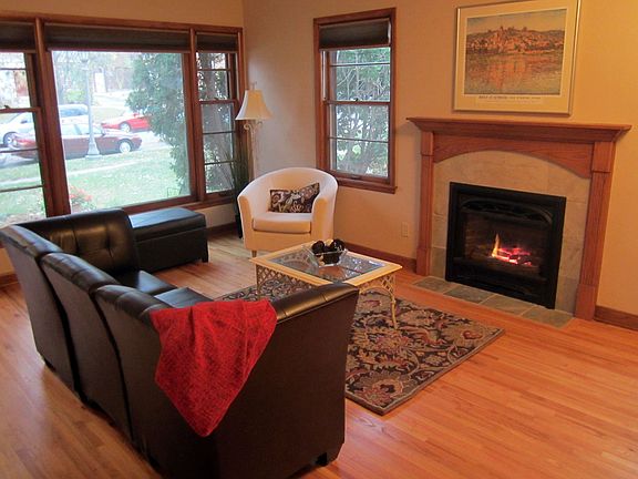 Spacious living room with gleaming hardwood floors and handsome gas fireplace.