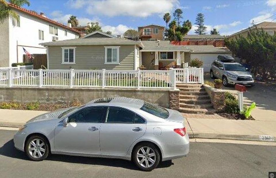 Front of house with fenced in yard and two gate entrances.