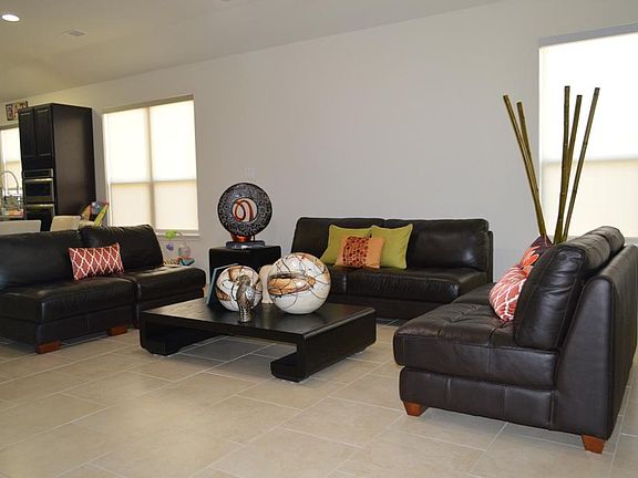 Spacious living area features custom window shades.