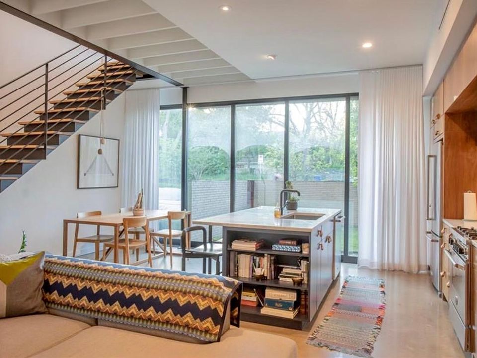 Downstairs living space with open concept kitchen and large floor to ceiling custom steel windows and 20' slider that opens up the West wall to grassy private courtyard.