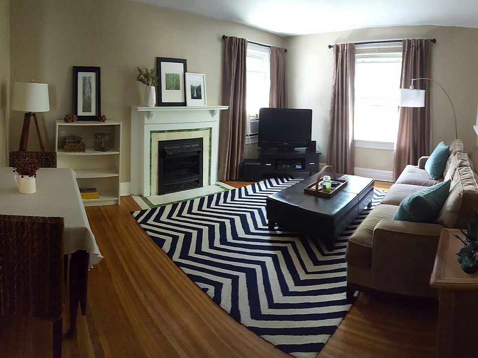 Spacious living room area with beautiful hardwood floors and decorative fireplace.
