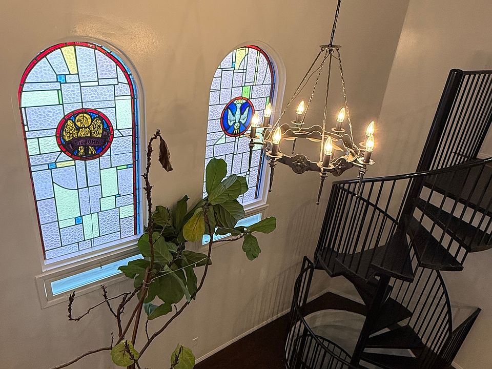 View of Main living area with original stain glass windows and cathedral ceiling from Loft/2nd bedroom