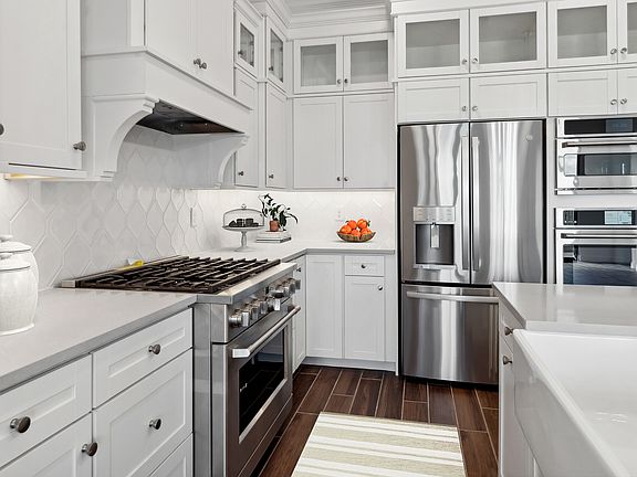 Kitchen with glass upper cabinets and hexagonal backsplash