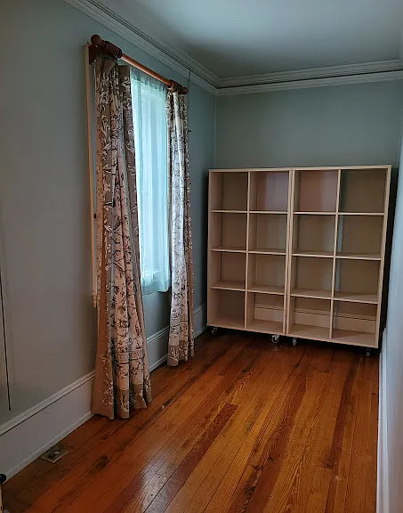 One bedroom long and narrow, full or queen bed width, bookcases on wheels, can be used as bed headboard