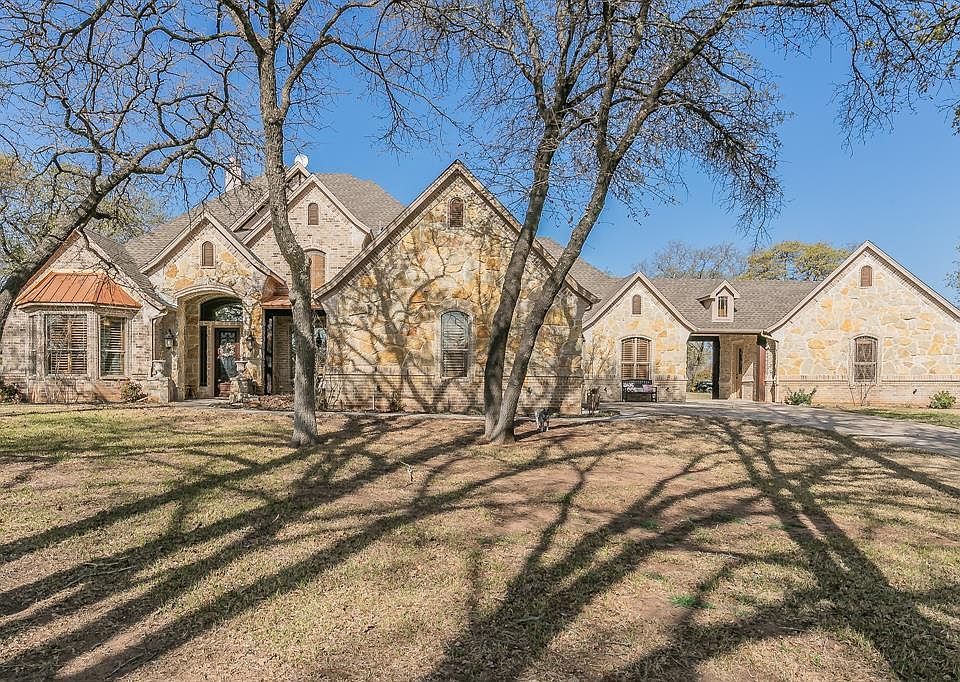 French country style house featuring a front yard and stone siding