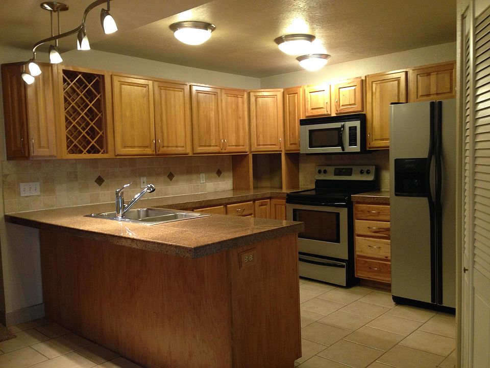 Spacious kitchen with granite counters and gas stove.