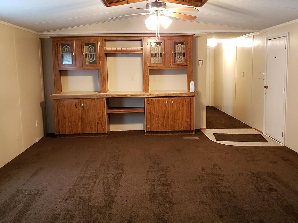 Living room showing the entertainment center, ceiling fan and front door.