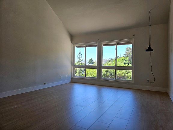 Large living room with cathedral ceilings. Comes with curtain rod for the windows and a light hanger in the corner (as shown).