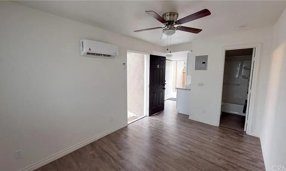 View of entrance to the living area, door to bathroom, and door to private backyard patio through the kitchen.