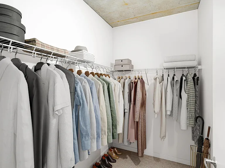 A spacious closet with open shelving and hanging space, providing a simple, organized setup for everyday storage and wardrobe planning.