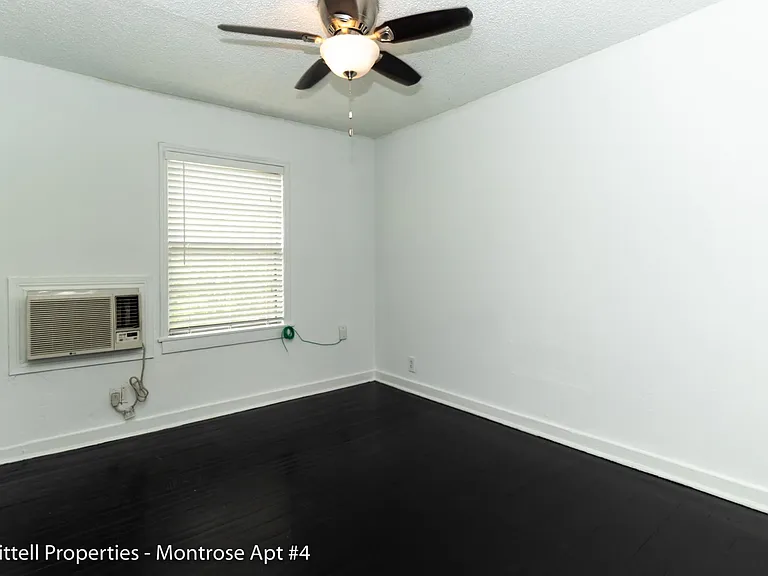 Bedroom A/C unit next to window. Bedroom also has a ceiling fan.
