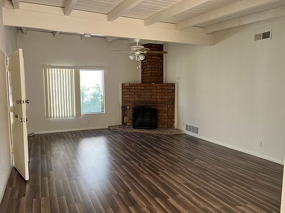 Large open family room with ceiling fan and beamed ceiling