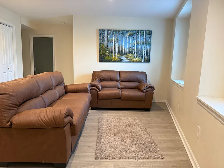 Comfortable shared living area with two sofas, durable flooring, and an open layout ideal for relaxing or socializing.