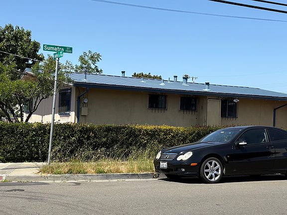 The house features a new metal roof and wooden fence.