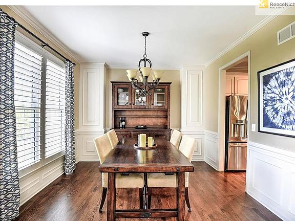 Dining w/ plantation shutters and hardwood floors.