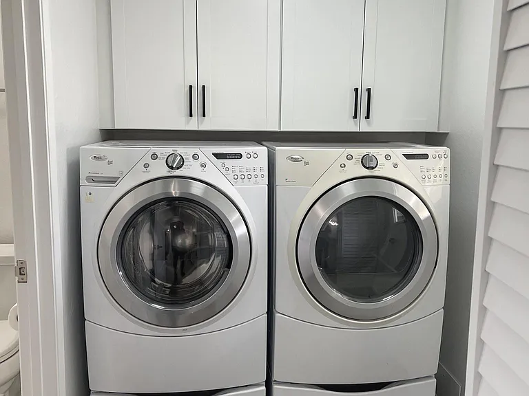 Bright, clean laundry room with washer and dryer included.