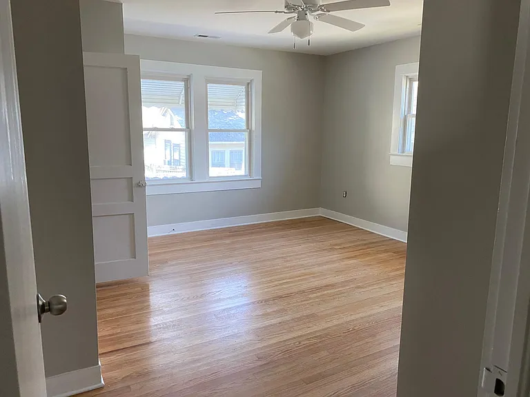 Look at this main bedroom! Gorgeous refinished 1940's solid wood flooring. Two closets, private bath added in the remodel with tile surround tub and luxury vinyl plank easy care bathroom flooring.