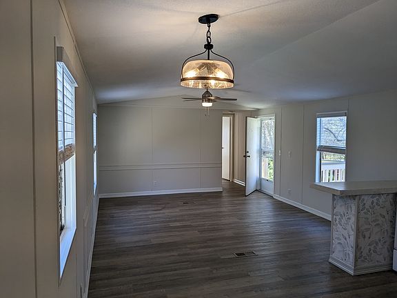 living room with bar to kitchen, windows on all sides