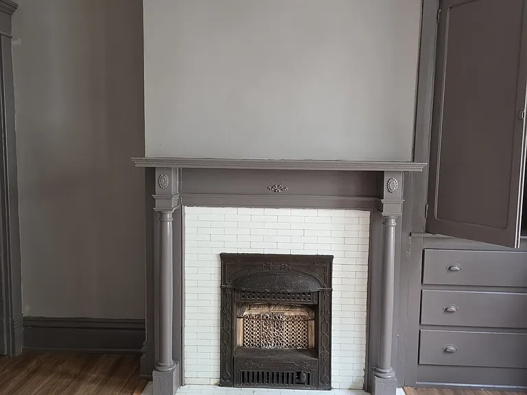 Dining room fireplace with built in china cupboard on right.