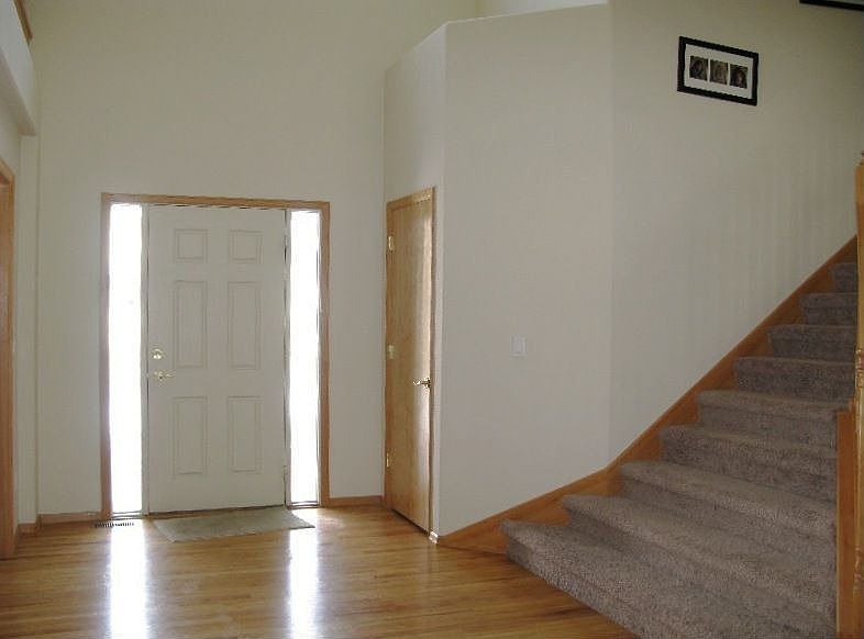 Dramatic front entry with wood floors and coat closet 