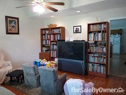 Cathedral ceiling in the living room with ceiling fan and canned lighting.
