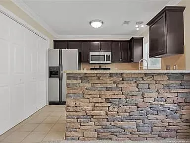 Bar height countertop with brick fascade with left-hand side view of laundry closet