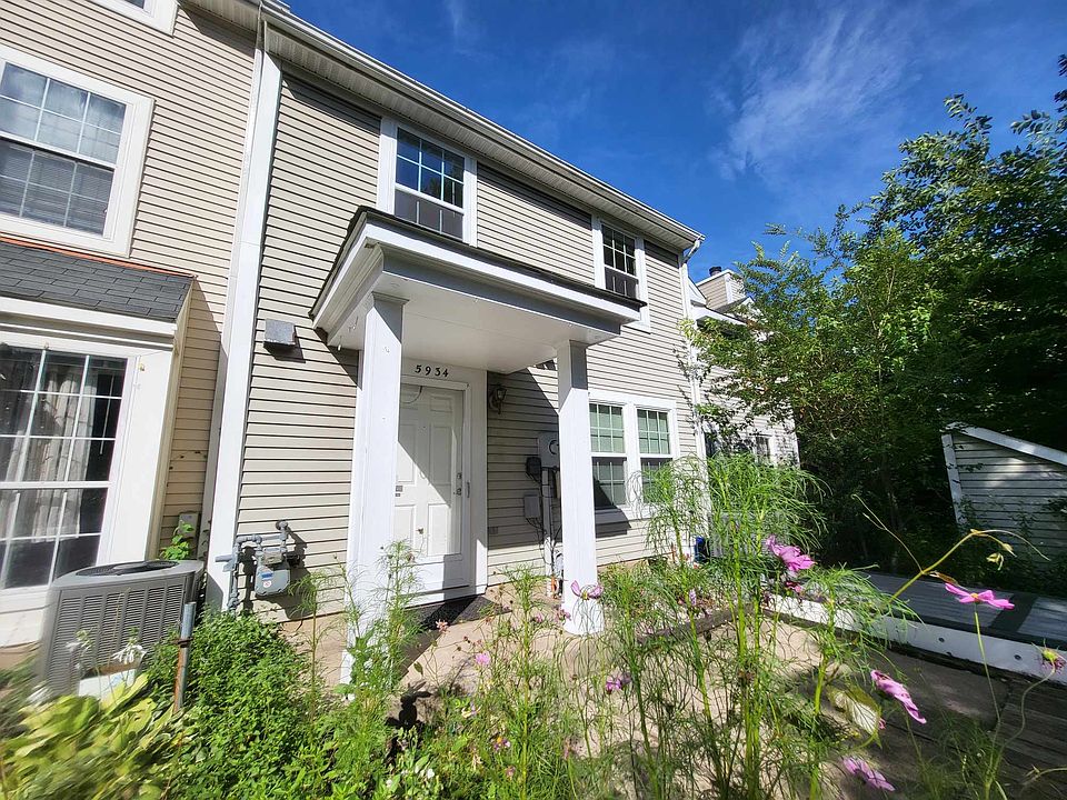 Front of house w/ privacy hedges, small deck, & garden