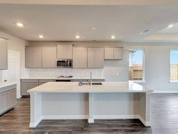 The kitchen is a chef s dream This spacious kitchen features a large center island and walk-in pan