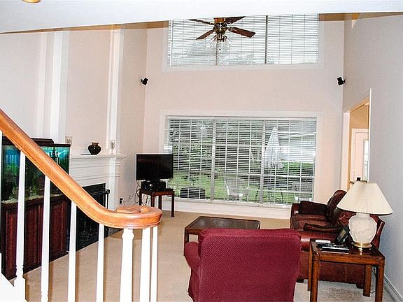  A view of the spacious and inviting family room with high ceilings and a wall of windows.