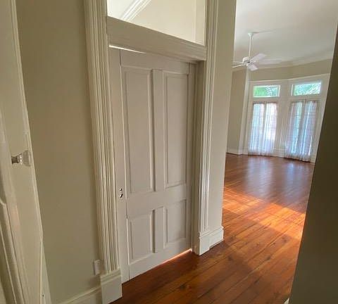 View from hallway inti livingroom. French door going out to front covered porch. Original heart pine floors.