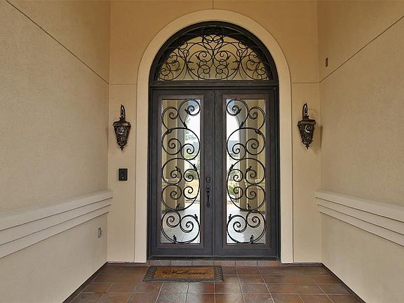Double wrought iron doors greet you as you approach the entrance of this estate.
