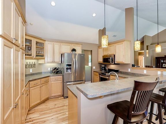 Spacious kitchen with maple cabinetry, under cabinet lighting and stainless steel appliances.