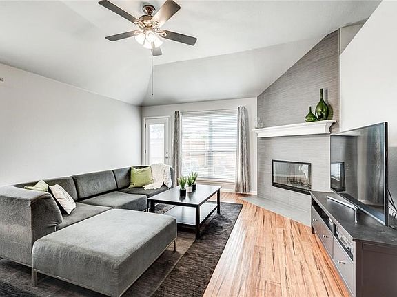 This second living area offers great space. The wood burning fireplace has been remodeled and has a sleek, transitional design.  Engineered wood floors, fresh paint, vaulted ceiling, nice fan with light kit.