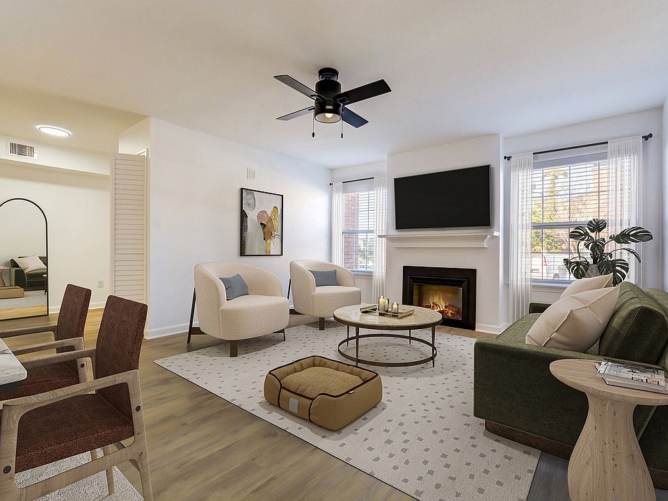 A spacious living area with cozy fireplace is shown at ReNew on Cantrell, featuring modern furniture and decor.