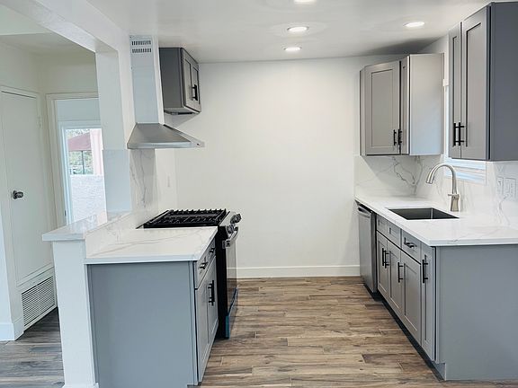 Brand new gray kitchen cabinet with new stove and dishwasher.