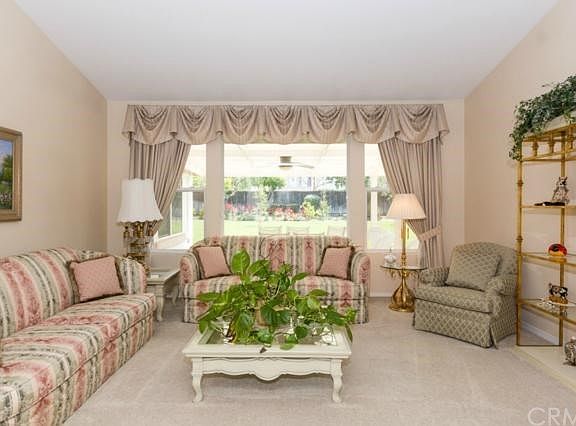 Formal living room with large windows looking out to beautifully manicured yard.