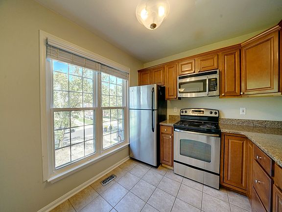 Naturally sunlit gourmet kitchen with granite countertops & stainless appliances
