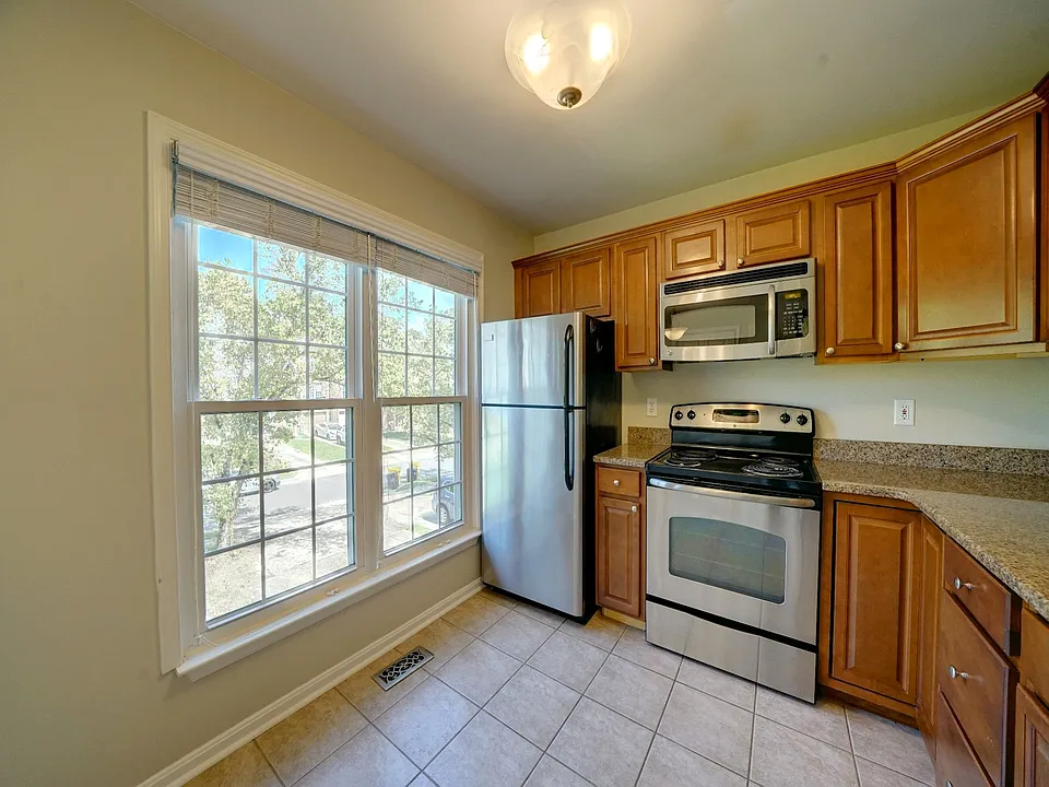 Naturally sunlit gourmet kitchen with granite countertops & stainless appliances