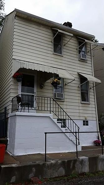 Front with newer retaining wall and raining