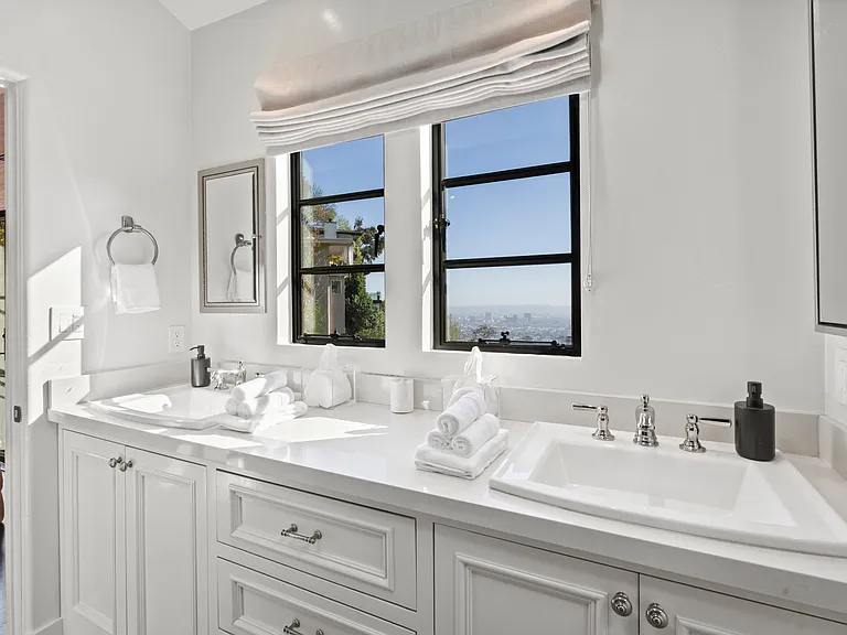 Refresh in a sunlit ensuite with a double vanity and skyline views.