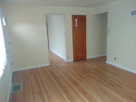 Living room view of kitchen, storage/pantry and hallway to bedrooms.