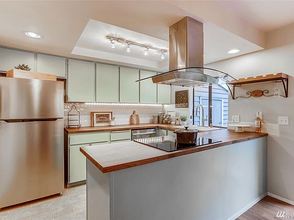 Stainless steel appliances, stylish wood countertops, and plenty of storage in the open kitchen. 