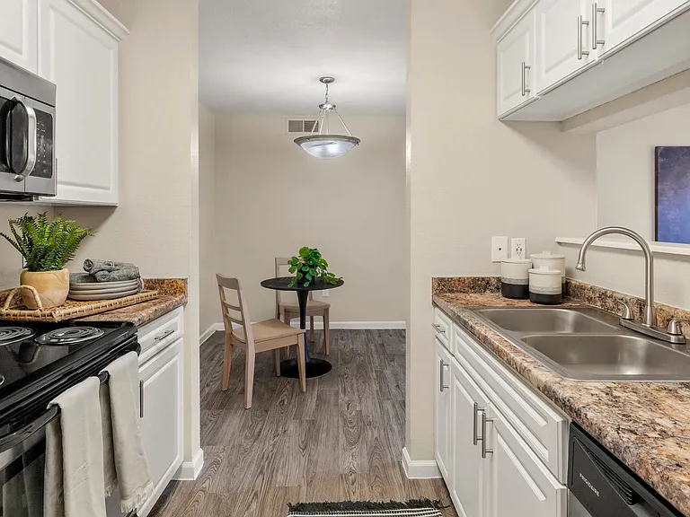 Chic kitchen with abundant cabinet space and wood-style flooring that seamlessly flows into the dining and living area. Perfect for hosting!