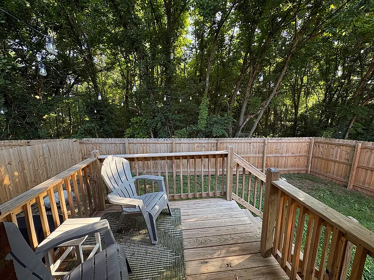 Quiet backyard with a privacy fence that backs up to trees with string lights! Propane grill included.